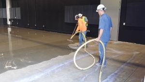Figure 6. Installation of a cement underlayment in which the thinness of the application can be observed. Prior to installation, the concrete subfloor had to be shot blast to ensure adequate bonding of the underlayment.