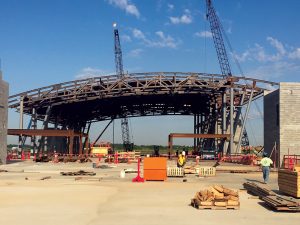 Erection of arched steel trusses spanning the width of concourse over the elevated concrete slab.
