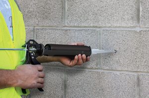Injecting adhesive into drilled holes in masonry to make an anchor connection.