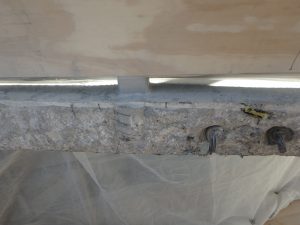 Figure 2. Concrete removal along a slab edge exposed grout pockets with missing hairpin anchor reinforcement.