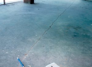 Structural design of elevated floor slab met the strength requirements, but the large cracks were not compatible with the proposed floor finishes.