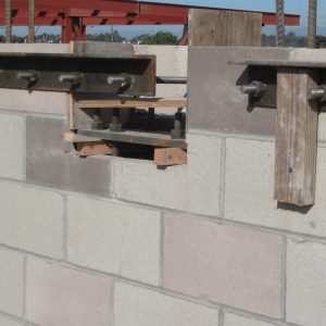 Anchor bolts are used to attach the ledger angle to the side of the masonry wall. Additional anchor bolts are used in the beam pocket for the base plate. Note that the ledger angle was installed over the face of the beam pocket, which had to be amended in the field.