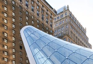 The anticlastic cable net supports a doubly curved glass façade.