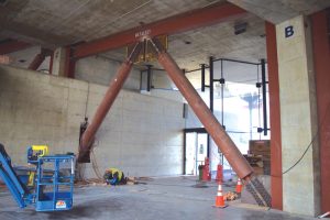 Installing braced frames adjacent to existing concrete.